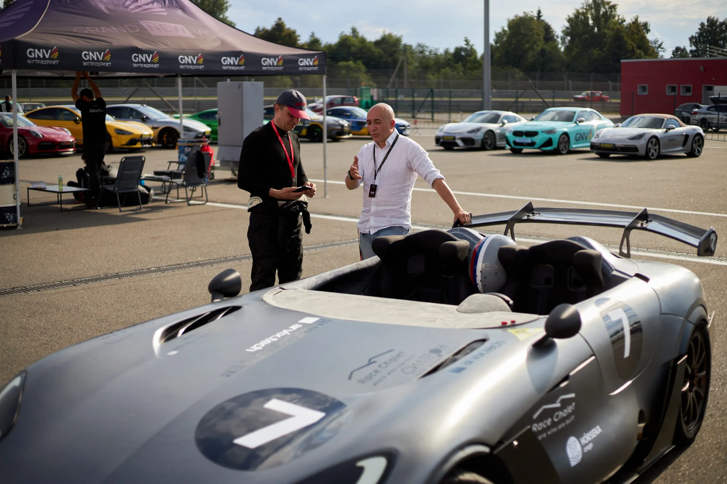 Mechanics beside the cars in the paddock between sessions